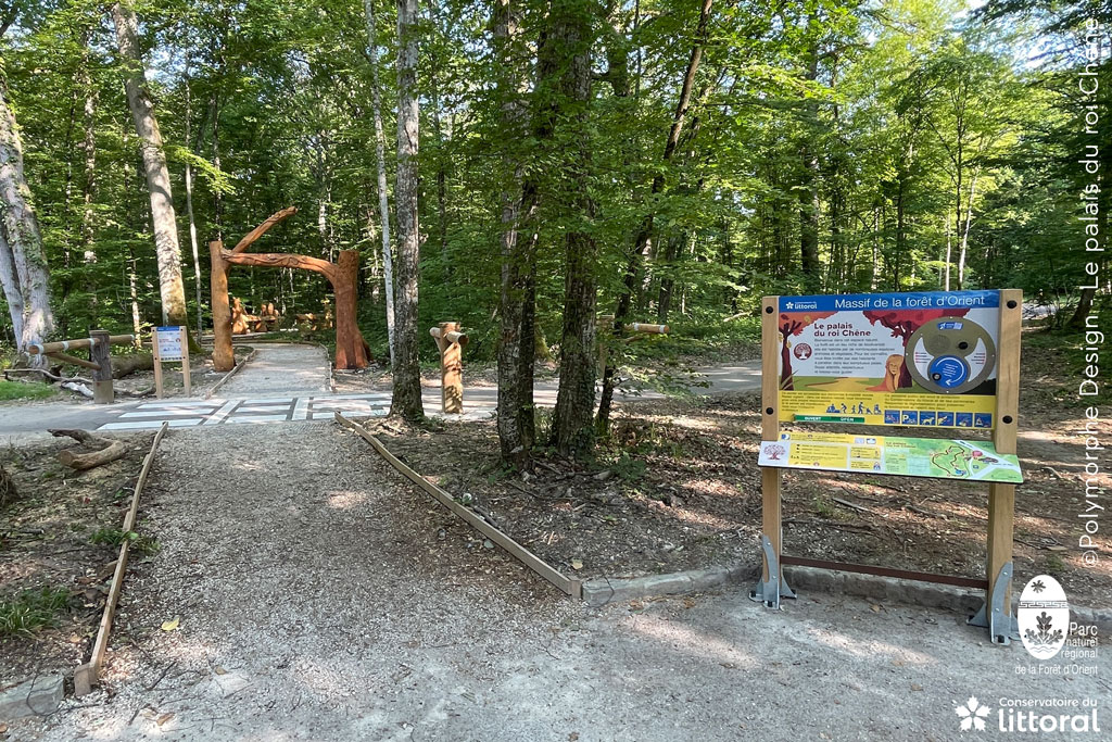 Photo du départ du sentier, avec un panneau d'information multisensoriel.